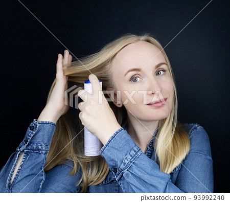 Dry shampoo. Blonde girl sprays shampoo on her hair. The problem of oily hair while traveling. An emergency remedy for excessive sebum production. Make your head clean without water Dry shampoo. Blonde girl sprays shampoo on her hair. The problem of oily hair while traveling. An emergency remedy for excessive sebum production. Make your head clean without water 93992240