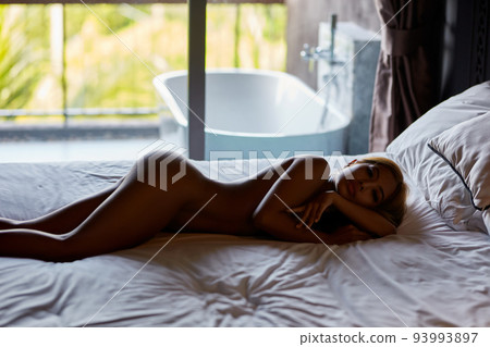 Silhouette of beautiful asian naked girl lies on the bed 93993897