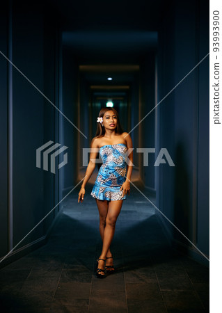 Indoor fashion portrait of young smiling woman posing in the corridor 93993900