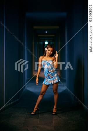 Indoor fashion portrait of young smiling woman posing in the corridor 93993901