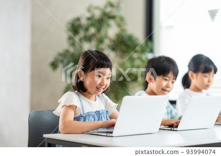 An elementary school student taking an IT class. 93994074