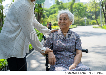 Caregiver help and care Asian senior or elderly old lady woman patient sitting on wheelchair in park, healthy strong medical concept. 93994962