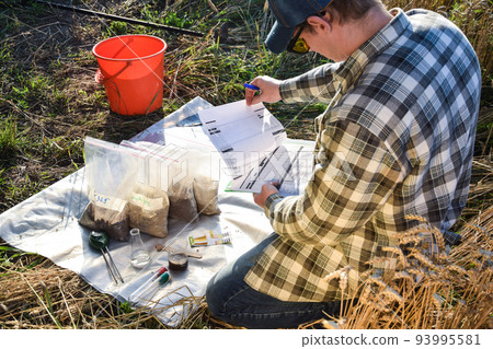 Farmer preparing soil samples for laboratory analysis outdoors Farmer preparing soil samples for laboratory analysis outdoors 93995581
