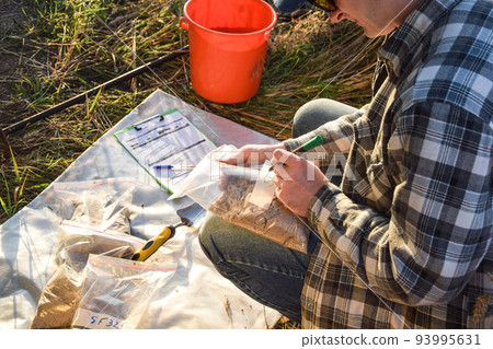Agriculturist preparing soil samples to laboratory analysis outdoors Agriculturist preparing soil samples to laboratory analysis outdoors 93995631