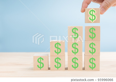Hand of men arranging Wood block cubic stacking step up with green Dollar Sign Blue Tone. Business growth success process. Up Trend. Wooden block and dollar mark Hand of men arranging Wood block cubic stacking step up with green Dollar Sign Blue Tone. Business growth success process. Up Trend. Wooden block and dollar mark 93996066
