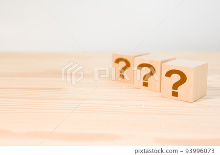 Cubes with question marks on wooden background, closeup. Wooden cube block shape with sign question mark symbol on wood table. Space for text Cubes with question marks on wooden background, closeup. Wooden cube block shape with sign question mark symbol on wood table. Space for text 93996073