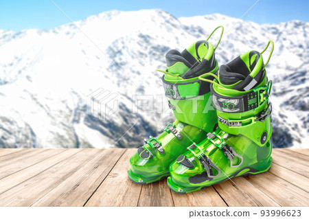 ski boots on a wooden table against the background of mountains. 93996623