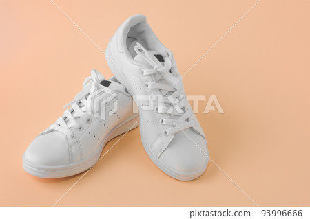 Pair of new white sneakers on pastel background. New white leather sneakers sports shoes. Copyspace 93996666