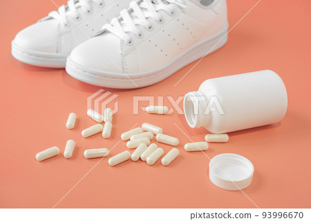 Sneakers and pills. Supportive drugs for the activities. Chondroitin capsules and sneakers. bright background Sneakers and pills. Supportive drugs for the activities. Chondroitin capsules and sneakers. bright background 93996670