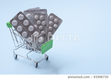 Grocery cart with pills, pharmacy shopping concept. Pills in the little grocery cart. copyspace 93996730