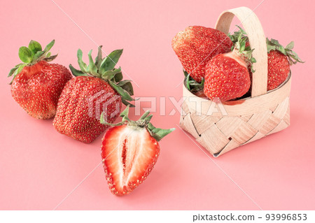 Strawberry. Fresh organic strawberries in a small basket on a pink background 93996853