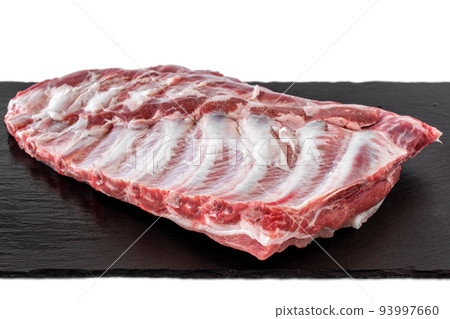 Whole raw pork ribs isolated on dark, black, stone board. isolated on white. spare ribs or belly. Whole raw pork ribs isolated on dark, black, stone board. isolated on white. spare ribs or belly. 93997660