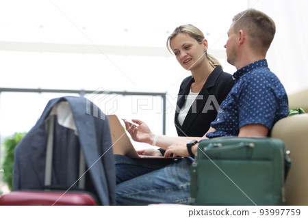 Young businessman is talking to secretary and asking to book tickets online for business trip Young businessman is talking to secretary and asking to book tickets online for business trip 93997759