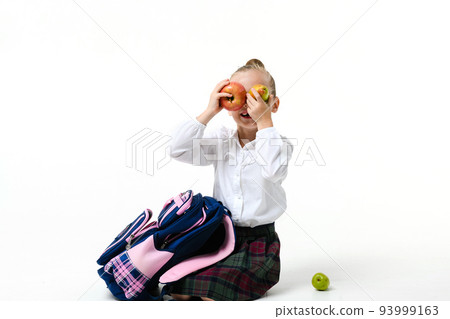 Girl fooling around with fruits sitting on a white background Girl fooling around with fruits sitting on a white background 93999163