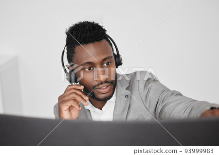 Call center, customer service and crm representative wearing headset while consulting with customer in telemarketing company. Serious black man in contact us and sales support working on a computer 93999983
