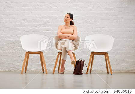 Employment, hiring and recruitment with a young business woman sitting on a chair waiting for her interview with human resources. Female shortlist candidate looking impatient or nervous for a meeting Employment, hiring and recruitment with a young business woman sitting on a chair waiting for her interview with human resources. Female shortlist candidate looking impatient or nervous for a meeting 94000016