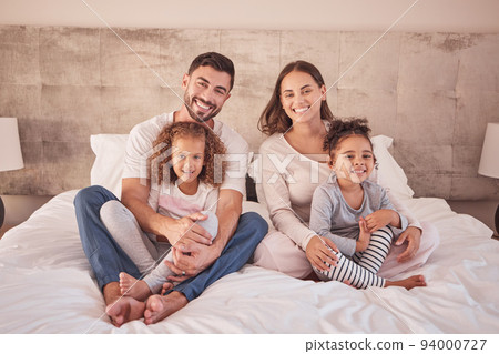 Family portrait on bed and happy mother, father and children wake up in the morning together with happy smile on face in their bedroom home. Happiness of mom and dad with kids while they relax 94000727