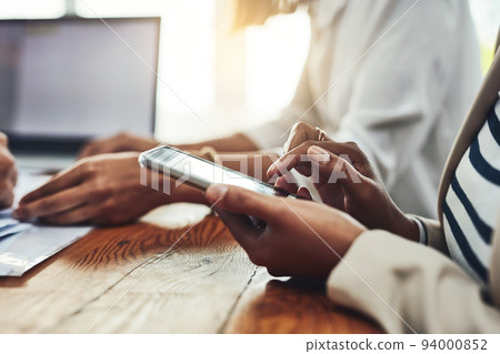 Closeup of a businesswoman hands on the phone texting colleagues, replying to messages or social media. Marketing professional female taking a break from working together with her team on a project Closeup of a businesswoman hands on the phone texting colleagues, replying to messages or social media. Marketing professional female taking a break from working together with her team on a project 94000852