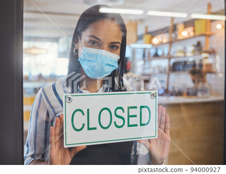 Compliance, safety and economic crisis closing store due to covid19 pandemic, sad and in debt. Small business owner frustrated about fail startup, hanging a sign on the window or entrance of shop 94000927