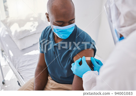Man getting covid vaccine, bandaid for protection and control of virus with a medical doctor at hospital. Expert, professional or healthcare worker helping patient, doing checkup and giving injection 94001083