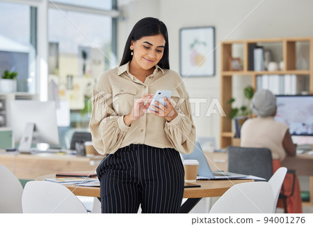 Entrepreneur on phone with social media online in a modern office. Business woman smile while chatting and checking email at work or sharing good news of a successful startup with a mobile smartphone 94001276