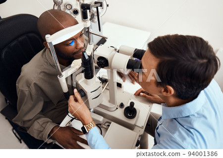 Eye, vision or sight test or exam of a patient above at an optometrist, optician or ophthalmologist. Testing and checking eyesight on a ophthalmoscope for optical glasses or contact lenses at clinic. Eye, vision or sight test or exam of a patient above at an optometrist, optician or ophthalmologist. Testing and checking eyesight on a ophthalmoscope for optical glasses or contact lenses at clinic. 94001386
