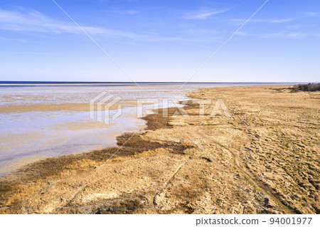 Copy space, blue sky and beach sand on a sea or ocean shore on a private, secluded and quiet island. Landscape view of a calm, serene and peaceful lake or bay with copyspace to relax and enjoy summer 94001977