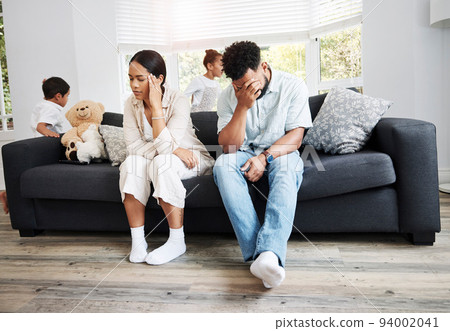 Sad, unhappy and stressed parents sitting on a couch near their children at home after an argument. Frustrated, tired and annoyed mom and dad are angry at hyperactive, noisy and naughty kids Sad, unhappy and stressed parents sitting on a couch near their children at home after an argument. Frustrated, tired and annoyed mom and dad are angry at hyperactive, noisy and naughty kids 94002041