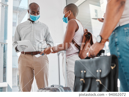 Covid security, passport and immigration at the airport during travel restrictions. Guard or compliance officer checking identity document of traveling woman in the corona virus or covid 19 pandemic Covid security, passport and immigration at the airport during travel restrictions. Guard or compliance officer checking identity document of traveling woman in the corona virus or covid 19 pandemic 94002072