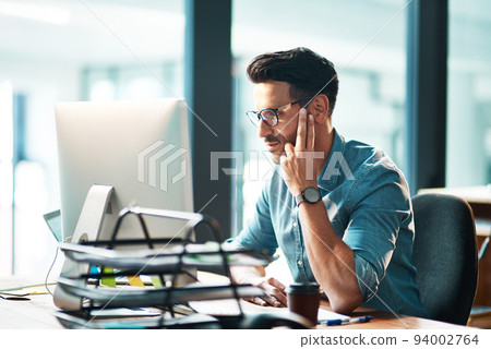 Professional corporate business man working on computer, browsing the internet and completing a project while sitting at a desk alone at work. One manager checking and reading emails online in office Professional corporate business man working on computer, browsing the internet and completing a project while sitting at a desk alone at work. One manager checking and reading emails online in office 94002764