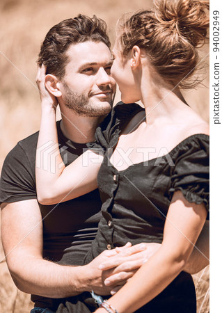 Romantic couple enjoying love, bonding and break on a getaway together on a sunny day outdoors. Relaxed boyfriend and girlfriend staring at eyes in a loving relationship on honeymoon, holiday or date 94002949