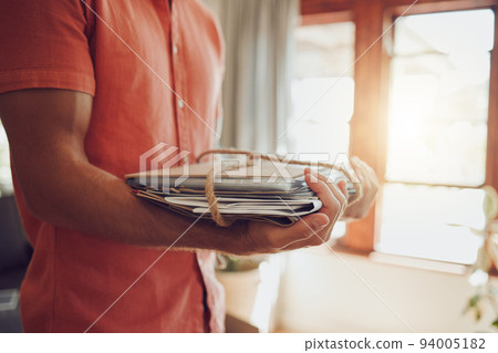 Recycling newspaper and magazine, sustainability and the planet and environment, green and clean energy for happy future. Man with paper and rope bundle, recycle and reuse in eco friendly modern home 94005182