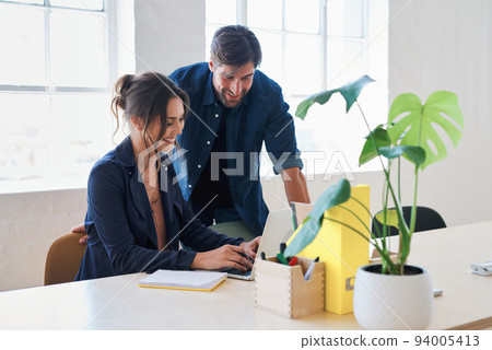 Two business people using laptop computer colleagues working in office sharing ideas Two business people using laptop computer colleagues working in office sharing ideas 94005413