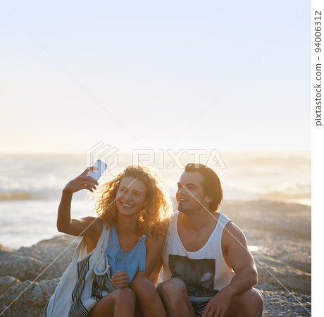 happy couple taking photo using smartphone on beach sharing romantic vacation together 94006312