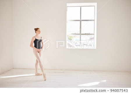 Ballet dancer training or practicing in a dance studio or class for a theater performance. Elegant and serious ballerina or performer dancing and learning contemporary style and performing alone 94007543