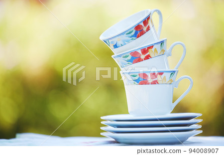 Garden cups, flowers and spring print china tea set for a calm morning in a backyard or park with a hot drink. Outdoors floral porcelain crockery catering for a relax, zen and quiet day in nature Garden cups, flowers and spring print china tea set for a calm morning in a backyard or park with a hot drink. Outdoors floral porcelain crockery catering for a relax, zen and quiet day in nature 94008907