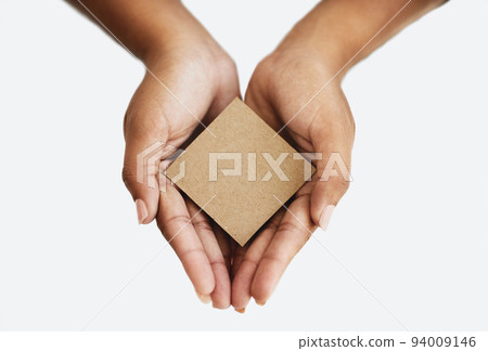 Closeup of the hands of a person showing a message, advertising a product or holding an empty paper or a cardboard card against a white background. Top view of woman promoting an item or sign 94009146