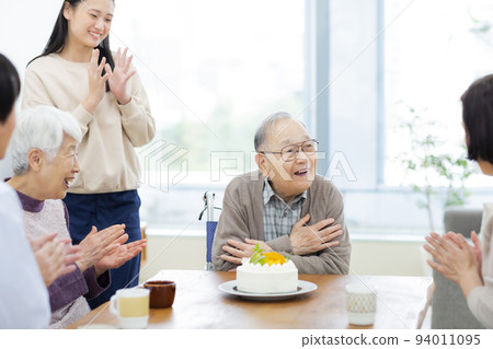 Three generation family grandchild celebrating grandfather 94011095