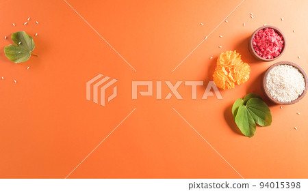 Happy Dussehra. Yellow flowers, green leaf and rice on orange background. Dussehra Indian Festival concept. 94015398