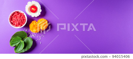 Happy Dussehra. Yellow flowers, green leaf and rice on purple pastel background. Dussehra Indian Festival concept. Happy Dussehra. Yellow flowers, green leaf and rice on purple pastel background. Dussehra Indian Festival concept. 94015406