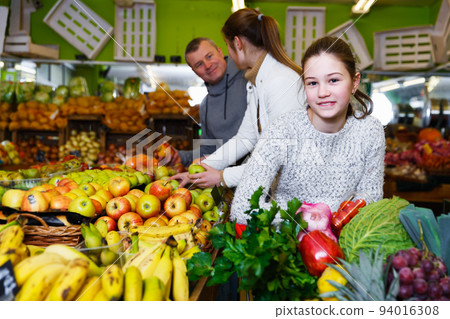 Girl with parents in greengrocery Girl with parents in greengrocery 94016308