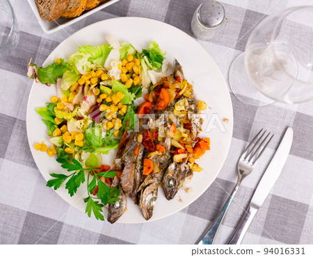 Appetizing fried blue whiting with vegetables 94016331
