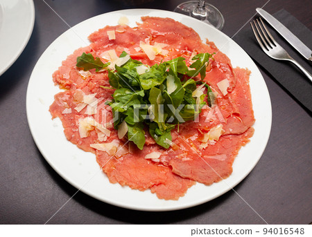 Carpaccio with cheese and arugula served on plate 94016548