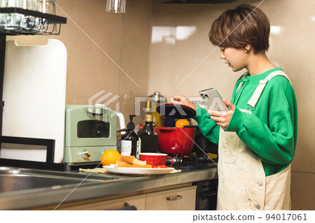 Young woman searching for cooking recipes on smartphone 94017061