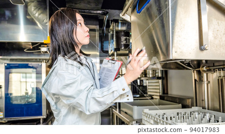 Image cut of a woman checking the kitchen Dishwasher Image cut of a woman checking the kitchen Dishwasher 94017983
