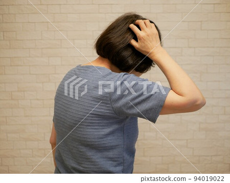 Rear view of an elderly woman who is worried about anxiety 94019022