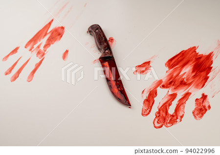 Bloody knife and hand prints in blood on a white table. Bloody knife and hand prints in blood on a white table. 94022996