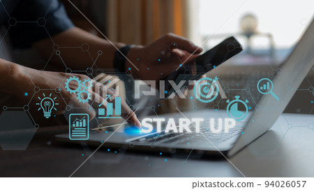 Start-up concept with icons for business and network connection on a modern virtual interface from a laptop computer. The man is putting his finger on the laptop. 94026057