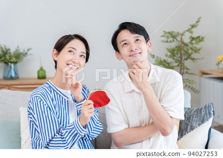 A couple with a wallet (money, savings, couple, worry, think) 94027253