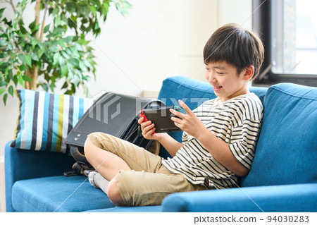 小學生坐在沙發上玩遊戲 94030283